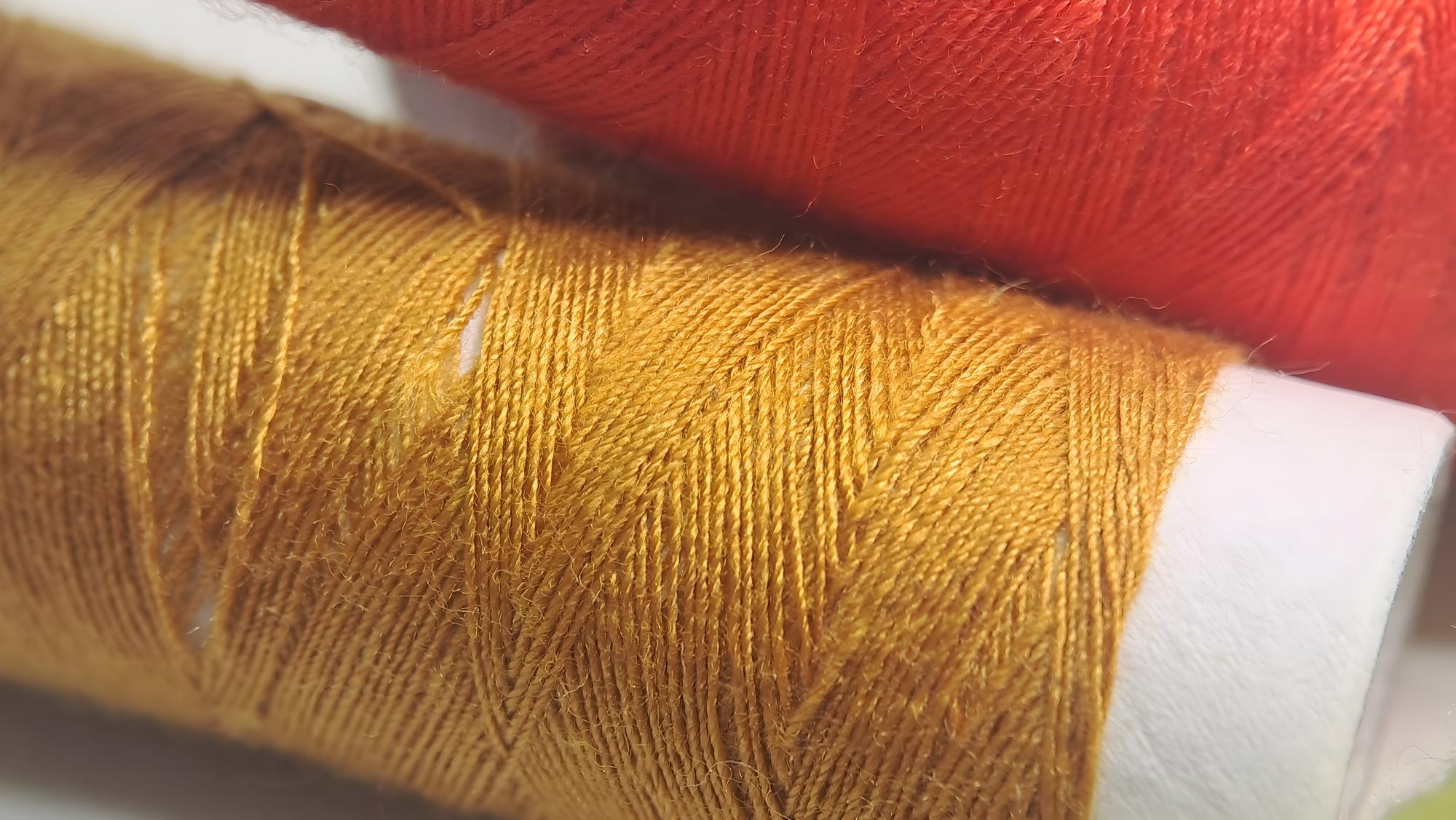 Close-up of hand embroidery on linen with gold thread